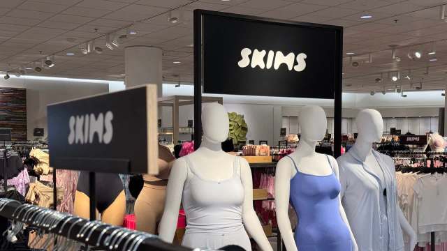 A SKIMS display featuring mannequins dressed in various clothing items in a retail store.