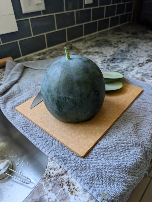 A Sugar Baby watermelon on a cutting board. 