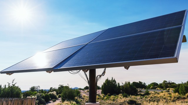 A solar panel on a mount in the desert.