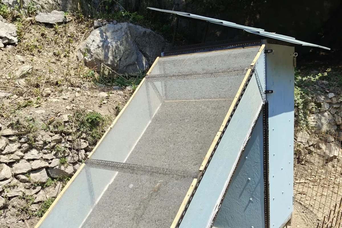 A solar dehydrator positioned on rocky terrain.