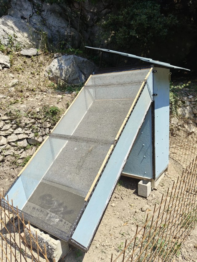 A solar dehydrator positioned on rocky terrain. 