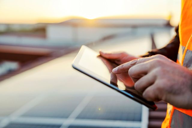 A solar technician working on a tablet.