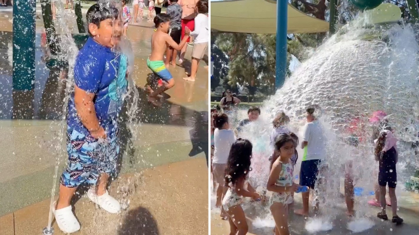Children play and splash in a water park, enjoying colorful spray fountains on a sunny day.