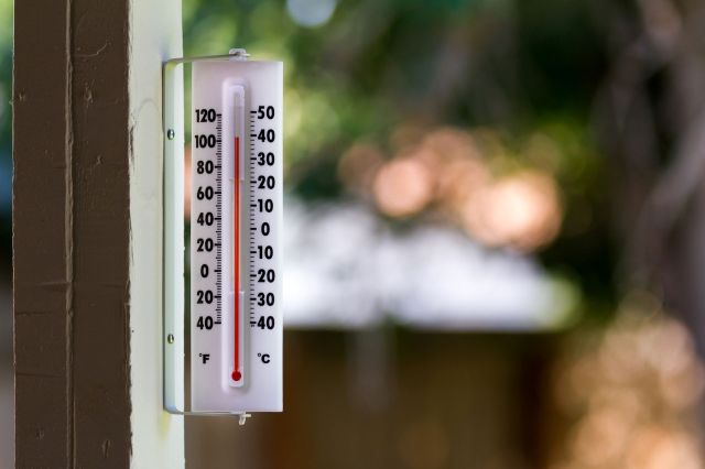 An outdoor thermometer reading over 100 F.