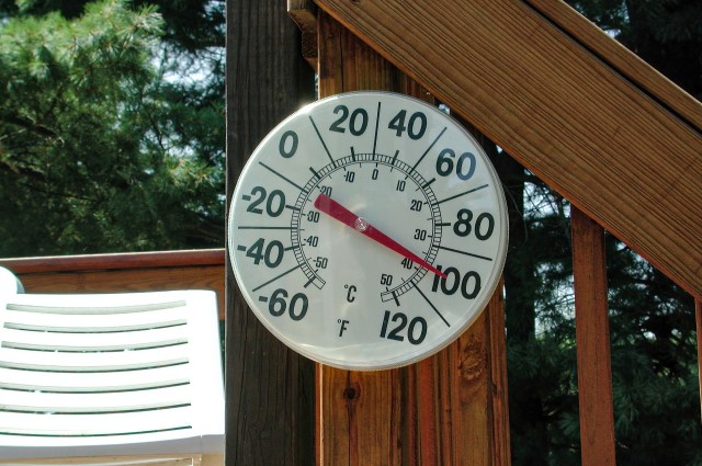 A thermometer showing an outdoor temperature of 100 degrees Fahrenheit.