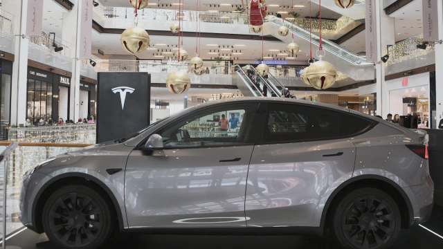 A silver Tesla Model Y displayed in a mall.