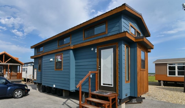 A blue tiny house with wooden accents.