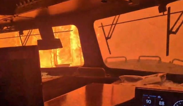 A wildfire surrounding a train.