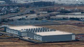 A data center and surrounding infrastructure near residential areas and highways.