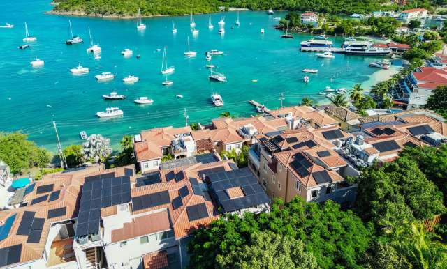 Residences with solar panels near a harbor.