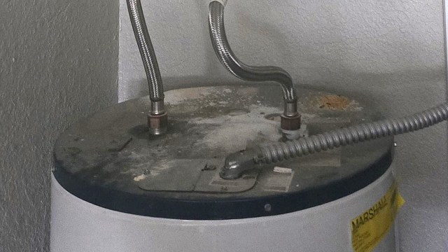 A water heater with corrosion on the tank.