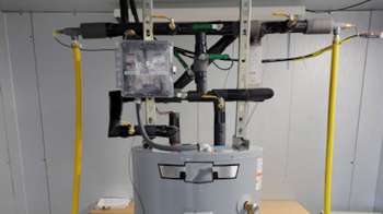 A water heater with connected pipes and a control panel mounted on a wall.
