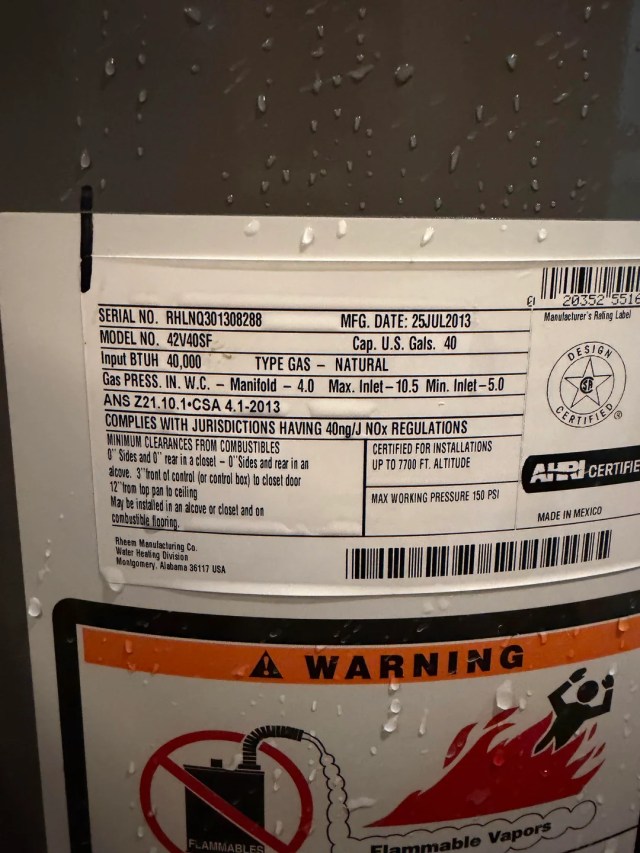 A water heater with visible drips on the surface.