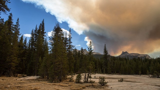 Wildfire smoke behind distant mountains.