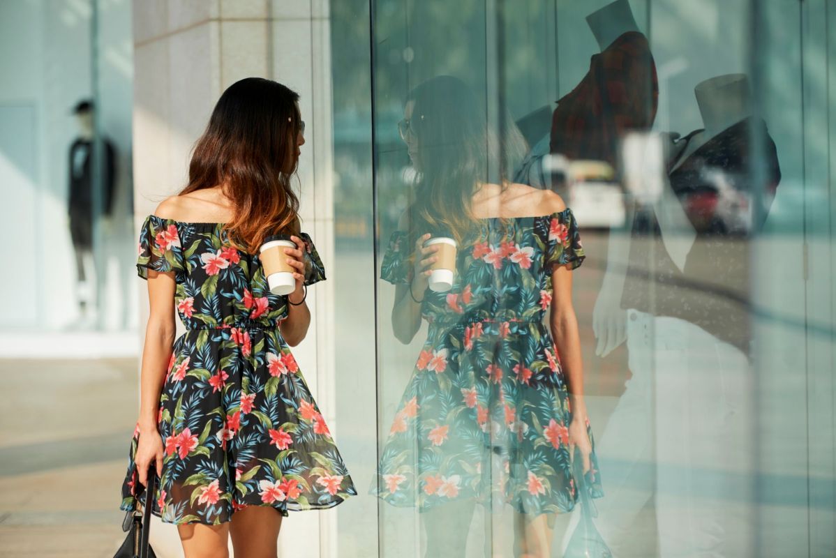 A woman walking by and looking in a store window.