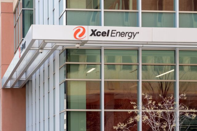 The exterior of an office building featuring a sign for Xcel Energy above large, reflective windows.
