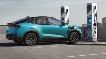 An electric vehicle is parked at a charging station on a rooftop.
