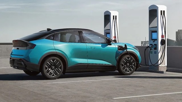 An electric vehicle is parked at a charging station on a rooftop.