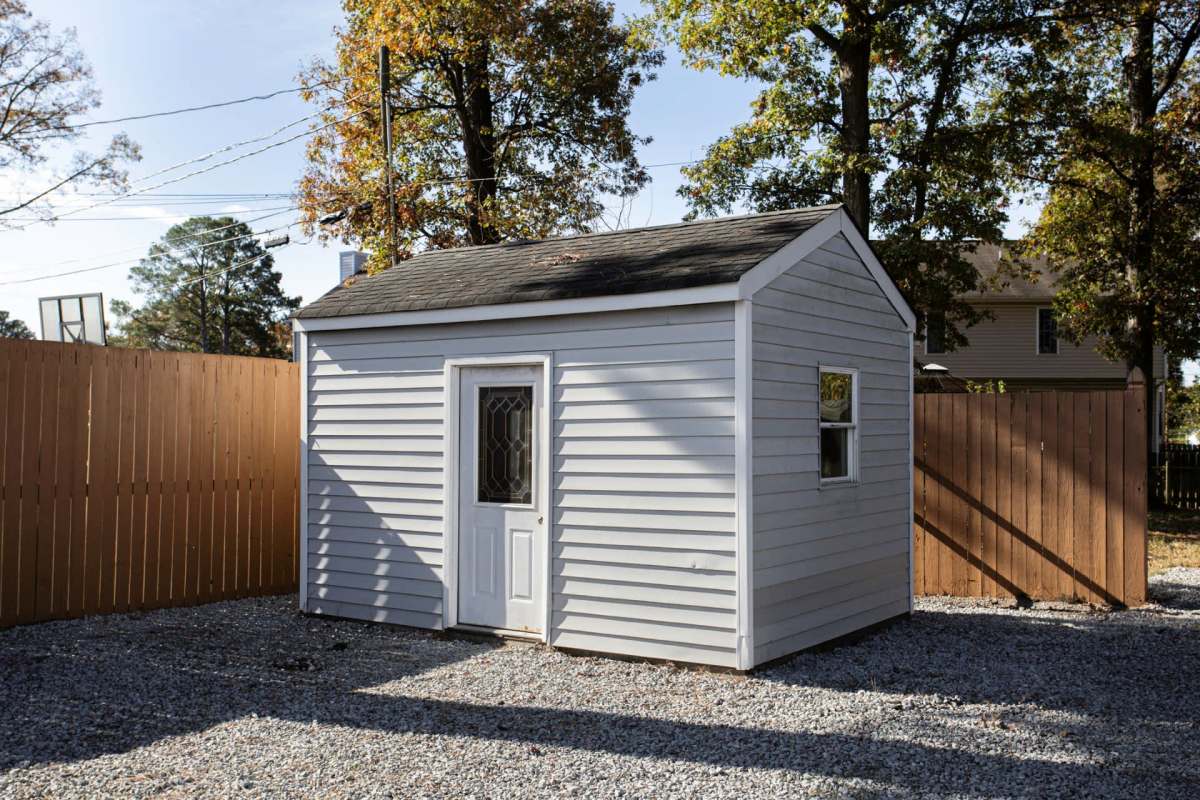 A shed in a fenced-in backyard.