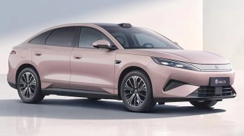 A pink electric BYD sedan parked on a smooth surface with a minimalist background.