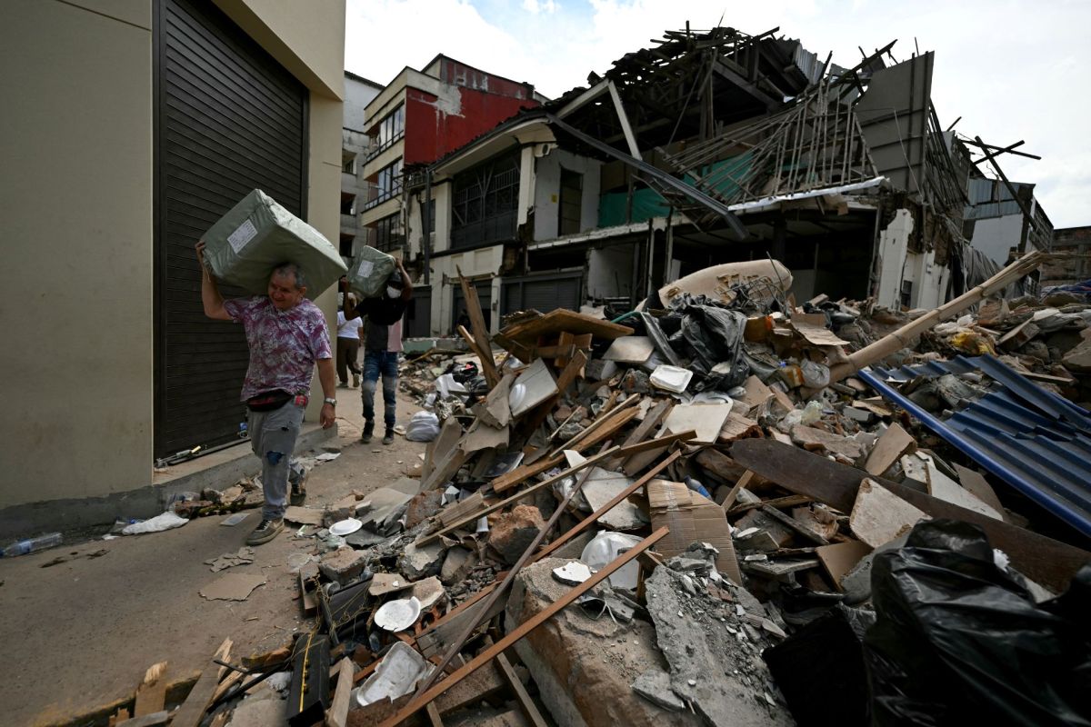 People walk by Colombian earthquake aftermath