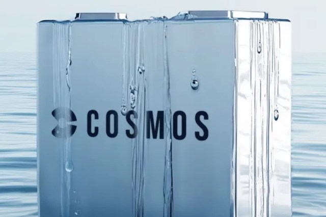 A metallic object with the logo "COSMOS" is surrounded by water droplets.