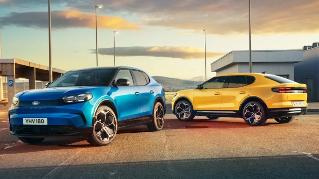 Two Ford cars, one blue and one yellow, parked in an outdoor setting with a clear sky in the background.