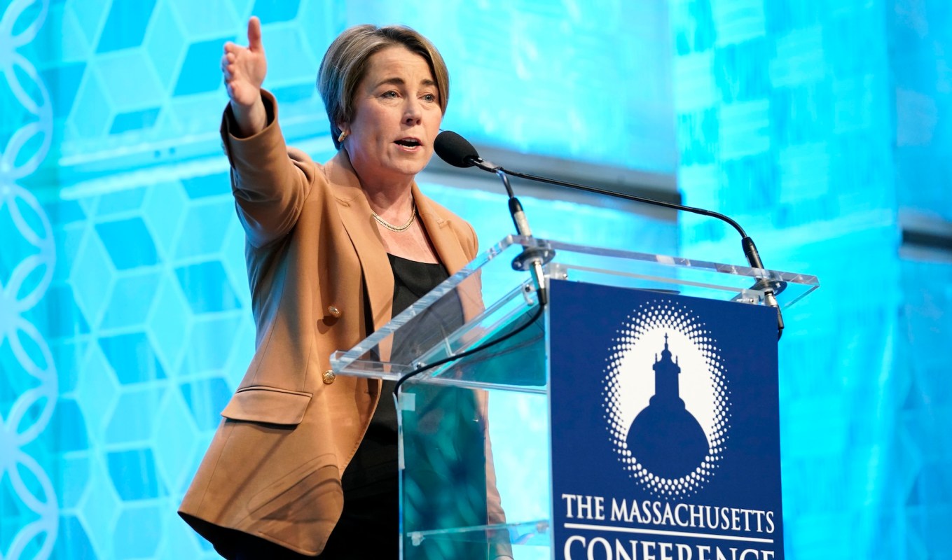 Massachusetts Governor Maura Healey gestures while addressing an audience at a Massachusetts conference.