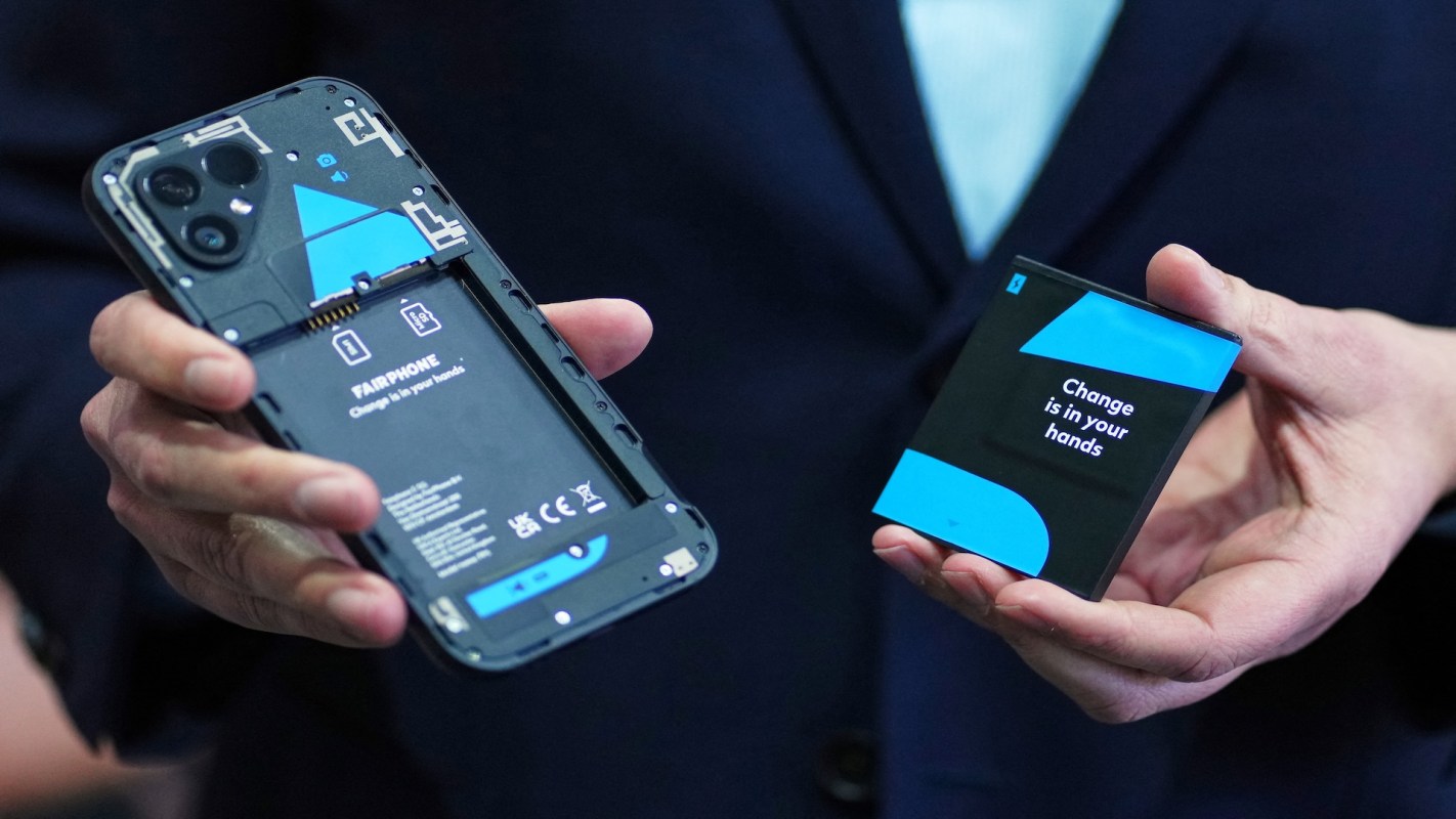 A person holding a Fairphone and battery.