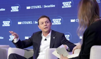 Voyager Technologies founder Dylan Taylor speaks during a panel discussion, with a woman listening and holding papers.