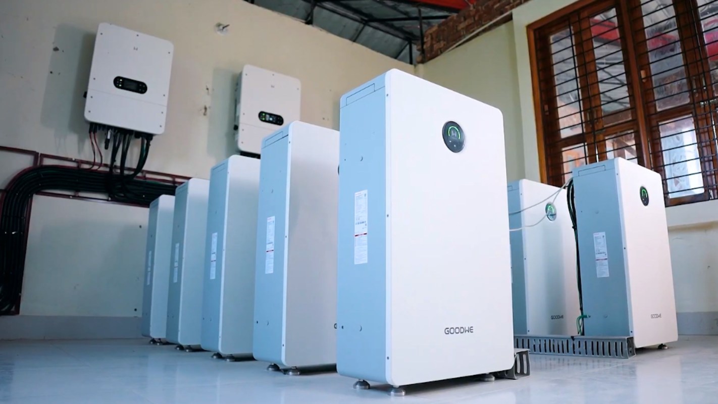 Several energy storage units arranged in a room with power supply connections on the wall.