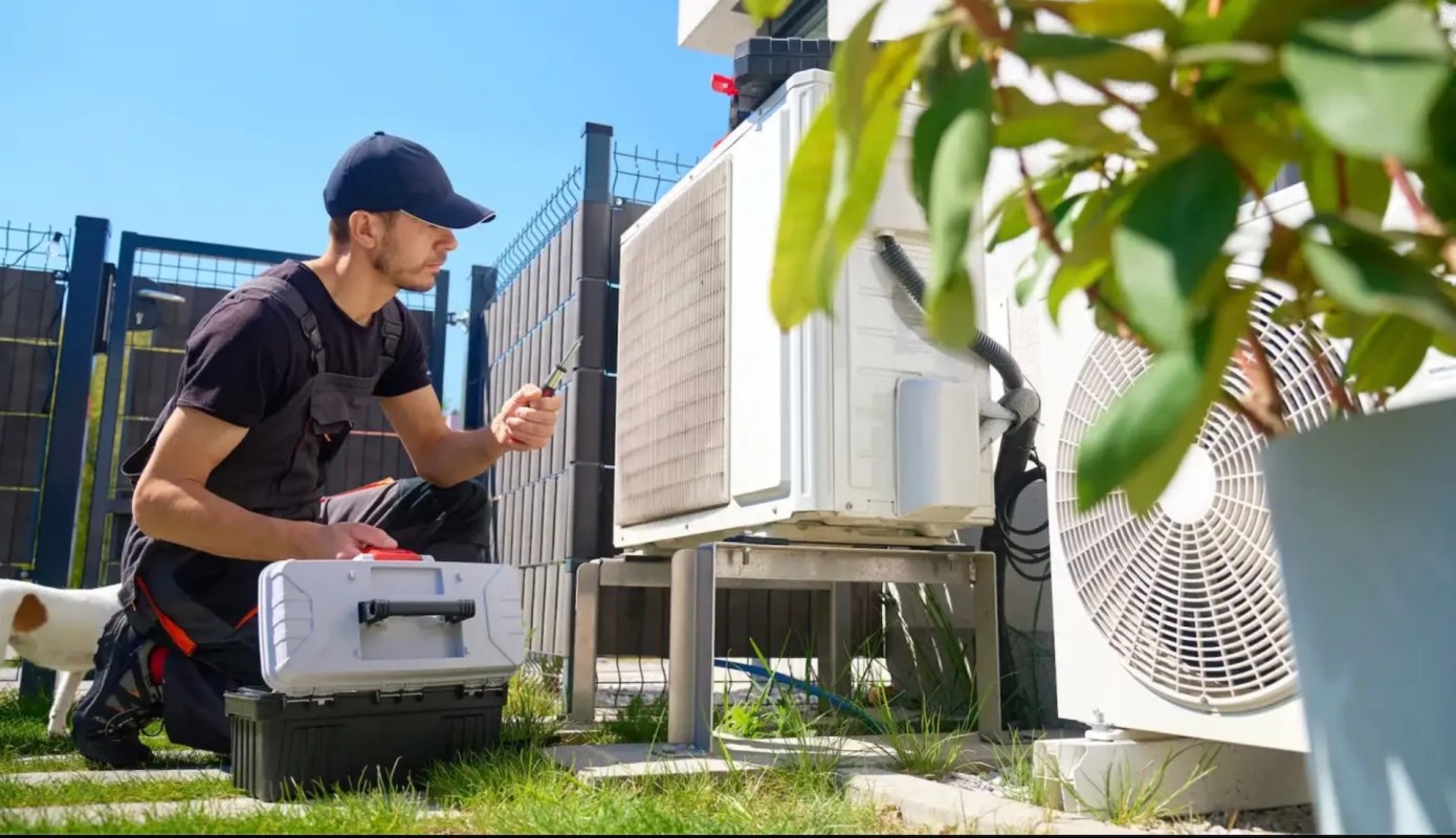 A HVAC tech working on an AC unit.