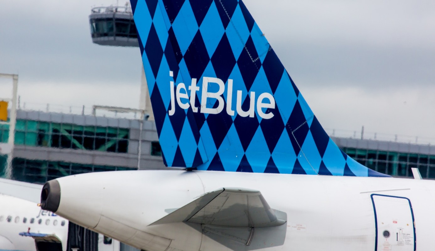 The tail of a JetBlue airplane with a blue and turquoise diamond pattern.