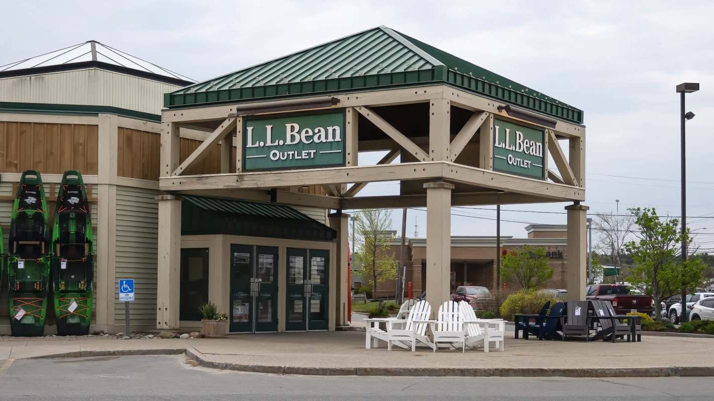 L.L. Bean Outlet storefront with green and white signage and kayaks displayed on the side.