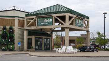 L.L. Bean Outlet storefront with green and white signage and kayaks displayed on the side.