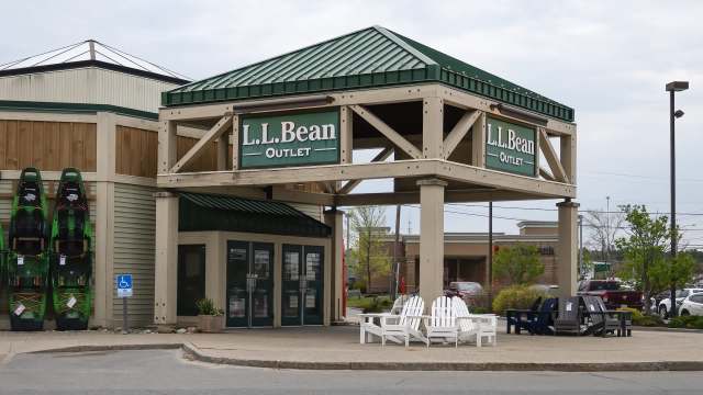 L.L. Bean Outlet storefront with green and white signage and kayaks displayed on the side.