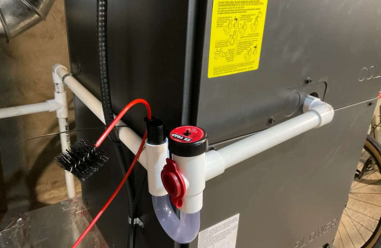 A mechanical setup with pipes, valves, and a brush connected to a machine in an underground environment.