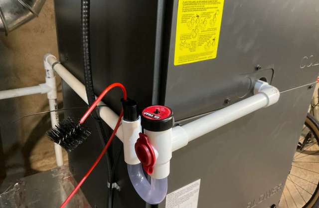 A mechanical setup with pipes, valves, and a brush connected to a machine in an underground environment.