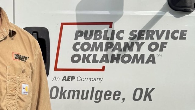 A worker next to a Public Service Company of Oklahoma sign.