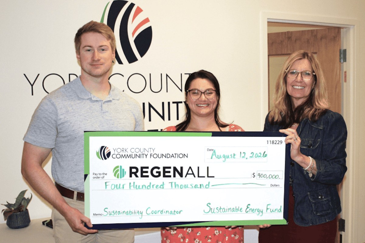 Three individuals hold a large check for four hundred thousand dollars from the York County Community Foundation.