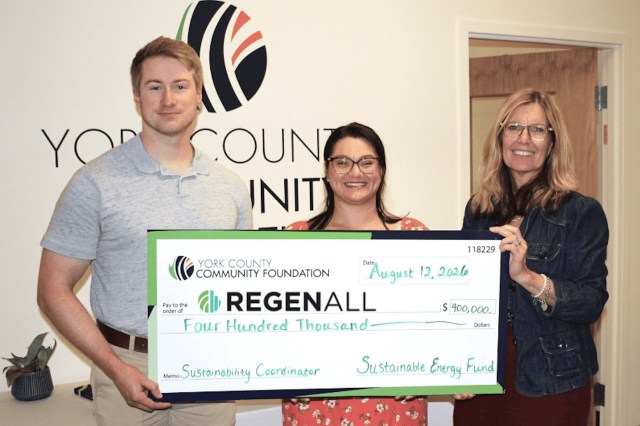 Three individuals hold a large check for four hundred thousand dollars from the York County Community Foundation.