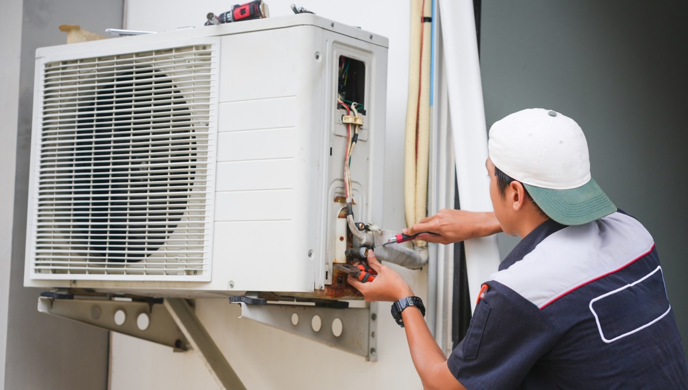 A technician repairing an HVAC unit.