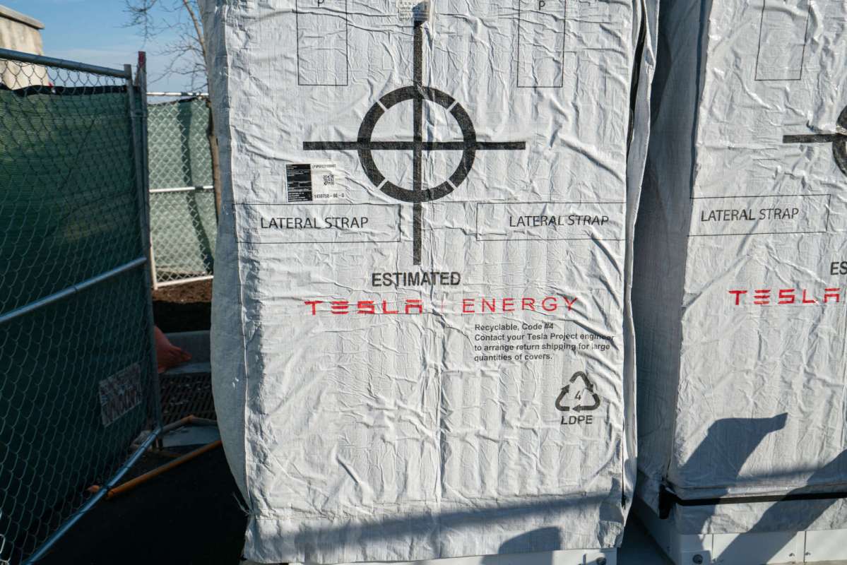 Two large weatherproof bags labeled with "Tesla Energy" and symbols for packaging instructions.