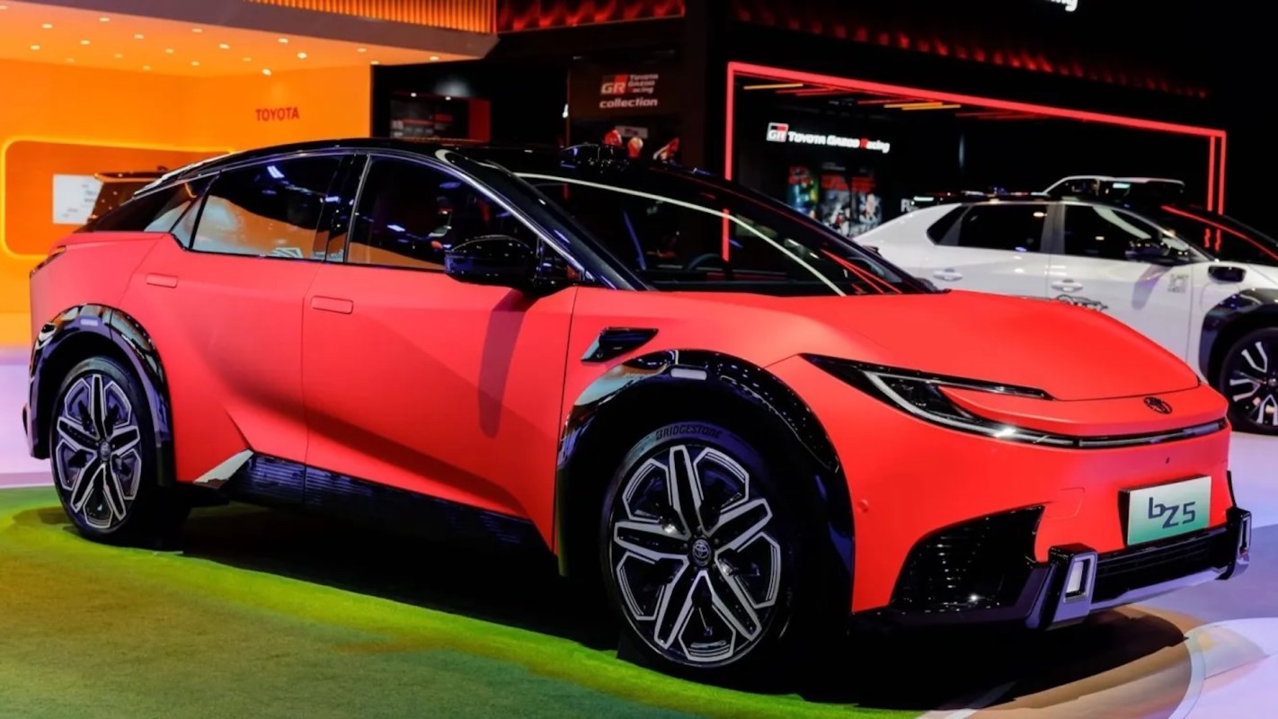 A red electric Toyota car displayed at an exhibition with contrasting black accents and a prominent logo.