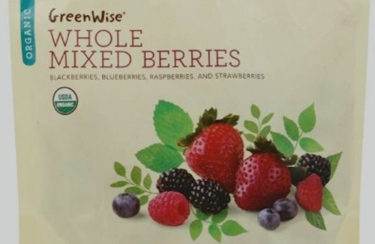 A package of mixed berries including strawberries, blueberries, blackberries, and raspberries with green leaves.