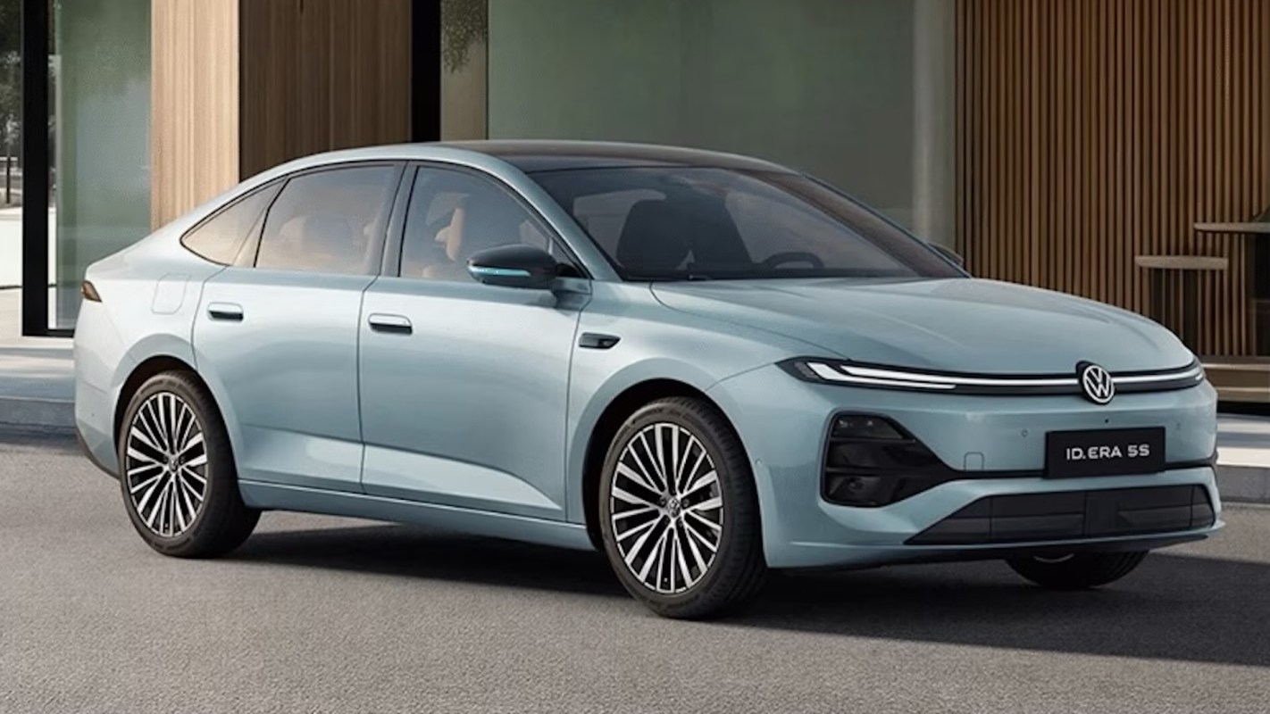 A light blue Volkswagen sedan parked outside a modern building.