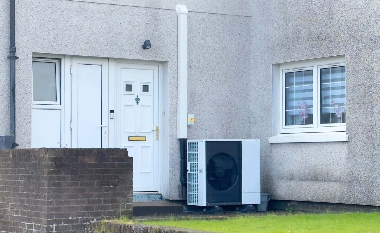 A front door with two windows and an air conditioning unit on a textured wall.