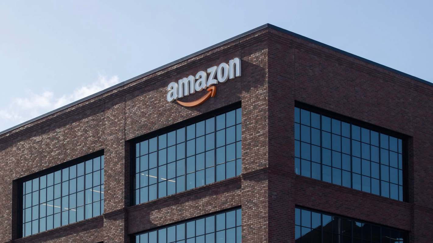 An Amazon logo on a brick building with large windows.
