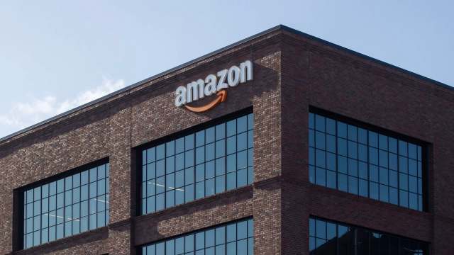 An Amazon logo on a brick building with large windows.