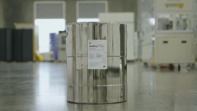 A metallic container labeled "Anthro" placed on a polished floor in an industrial setting.